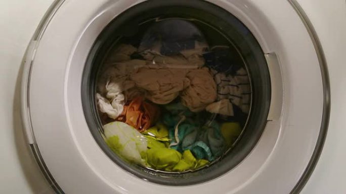 洗衣机里的湿衣服转动，透过前玻璃