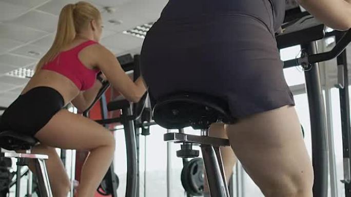 具有强大意志力和动力的女孩在固定自行车上训练腿部肌肉