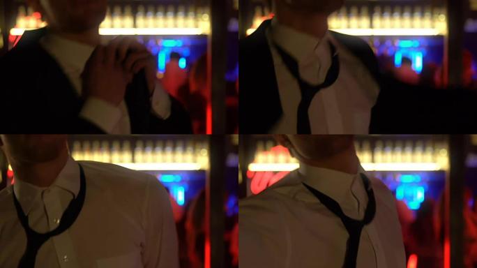 年轻的跳舞男子松开领带，脱下夹克，整夜狂欢