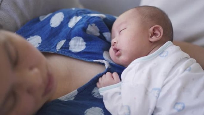 母乳喂养后睡在母亲身上的婴儿