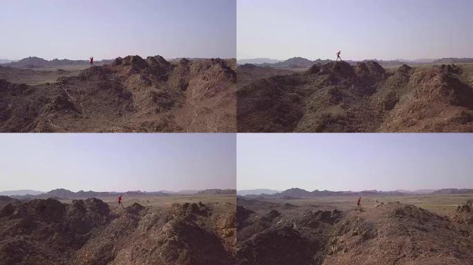 在沙漠中攀登落基山的越野跑者的鸟瞰图