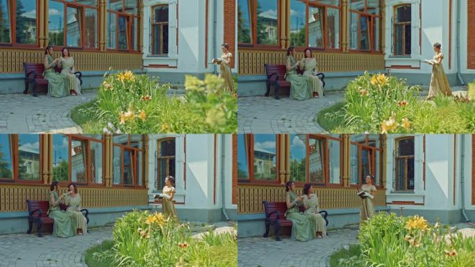 社会女士散步、喝茶和看书。穿着优雅的蕾丝连衣裙的女士们在一座古老的豪宅的院子里聊天，这是贵族的休闲。