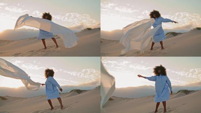 女孩舞者挥舞着飘动的布在沙漠中表演当代舞蹈。