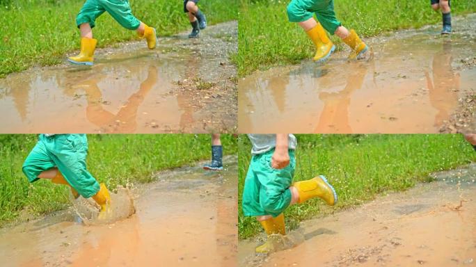 SLO MO两个穿着雨靴的男孩在阳光下穿过泥泞的水坑