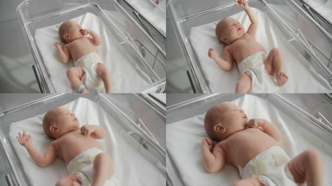 婴儿出生后躺在产科病房婴儿床中的婴儿肖像。可爱的新生儿呼唤母亲，感到精力充沛，失眠。分娩和医疗诊所的