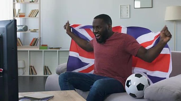 英国球迷挥舞旗帜为国家队加油，在家观看比赛