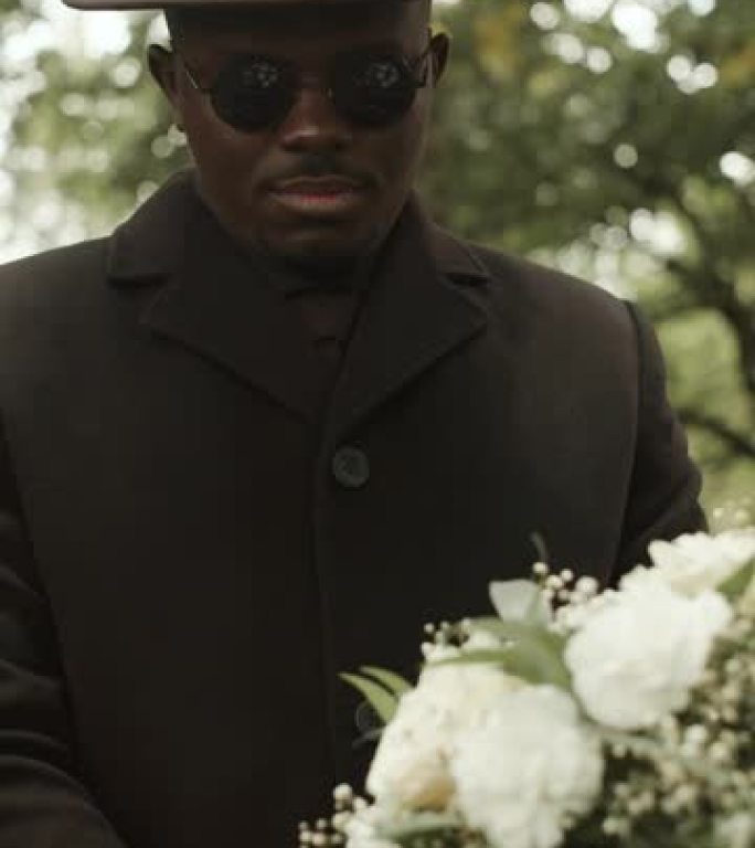 黑人在户外葬礼仪式上站在棺材旁
