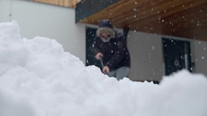 SLO MO LD男子铲雪并将其扔进相机