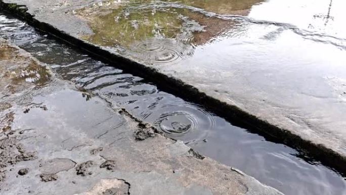 下雨时，水泥沟向河水流动