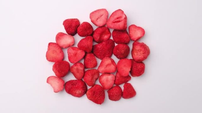 冻干草莓，是一种经过加工的水果，保留了食物的营养价值。在白色背景上隔离的一堆冻干草莓。