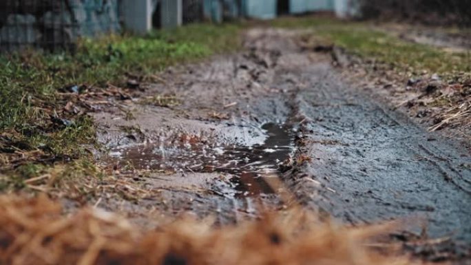 漏水的屋顶排水沟滴水在地面上形成的雨水水坑