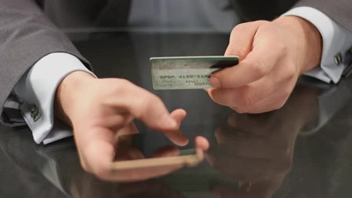 高级经理在智能手机上输入信用卡号