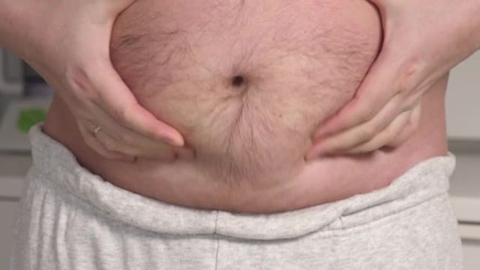 大肚皮的胖子露出他的胖肚子