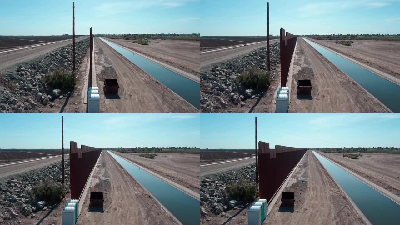在阳光明媚的日子里，鸟瞰了亚利桑那州尤马和墨西哥北下加利福尼亚州阿尔戈多内斯之间未完成的边界墙，
