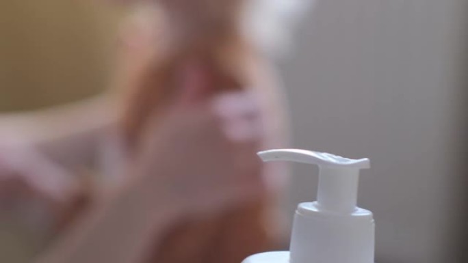 母亲的手在一个快乐的婴儿身上涂抹奶油。妈妈按摩一个微笑的蹒跚学步的孩子