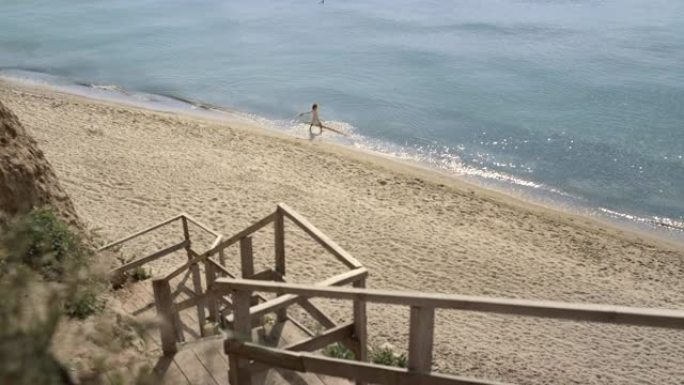 女人在远处行走海浪。年轻女孩在海水中泡脚