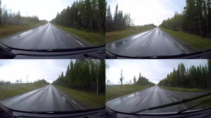 在雨中行驶在潮湿的道路上从汽车上看。在挪威的道路上驾驶汽车