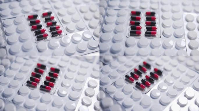 红色和黑色药丸躺在白色水泡之间，片剂在桌上，癌症药物的临床试验，具有活性物质和安慰剂作用的药物