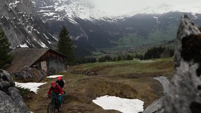 成熟的夫妇骑山地电动自行车穿越困难的山区地形