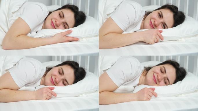 一个快乐的30岁女人躺在床上，抱着枕头睡着了