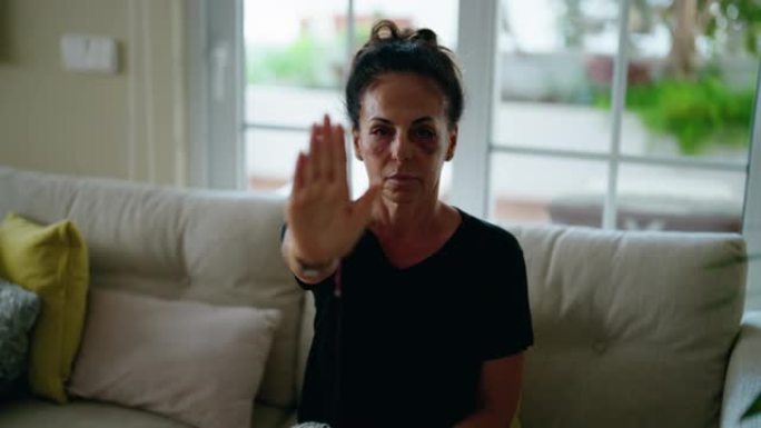 中年西班牙裔妇女在家里做制止家暴的手势