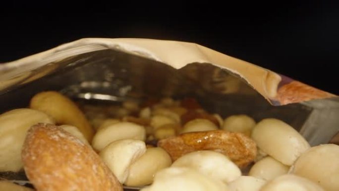 包装中的坚果混合物放在桌子上，还有一个装满蜂蜜的罐子，里面有一个摄像头，一个幻灯片，一个特写镜头。