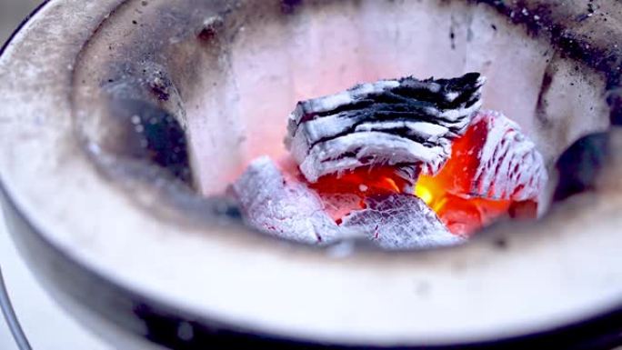 在木炭火盆上点燃木炭烤火