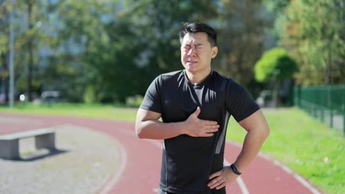 年轻的亚洲跑步者在城市体育场的跑步机上跑步后心脏病发作或胸痛