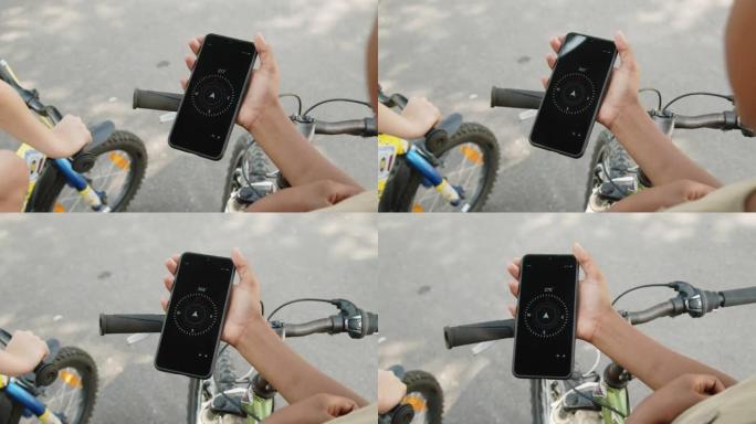 使用智能手机上的指南针骑自行车的不同孩子的手