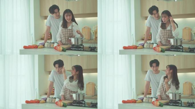 亚洲夫妇正在家里的厨房里帮忙切胡萝卜做鸡汤。一对情侣的浪漫场景
