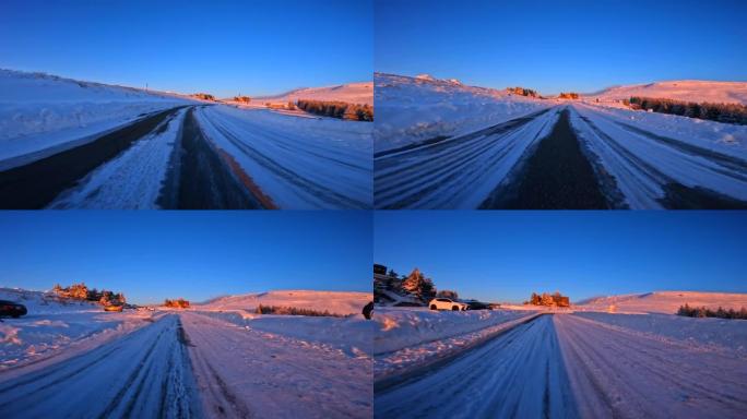 黄昏时在雪山路上行驶。