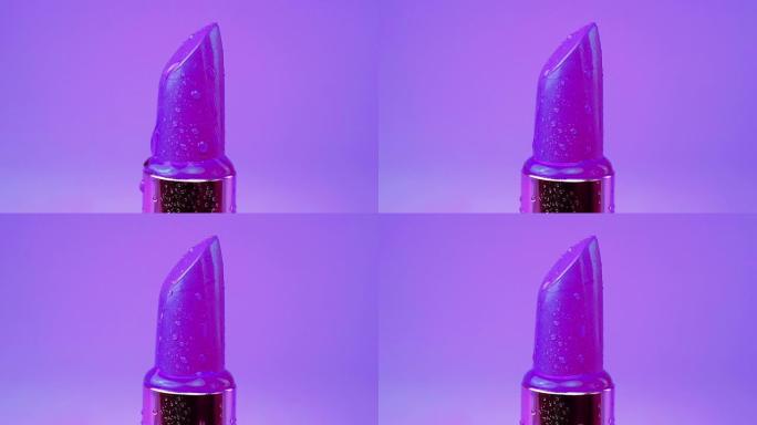 口红管与水滴隔离在紫色背景。