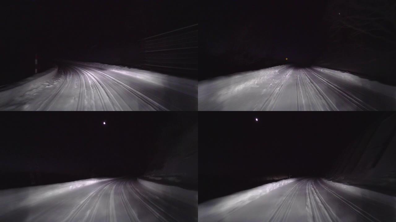 晚上在森林的雪路上开车。