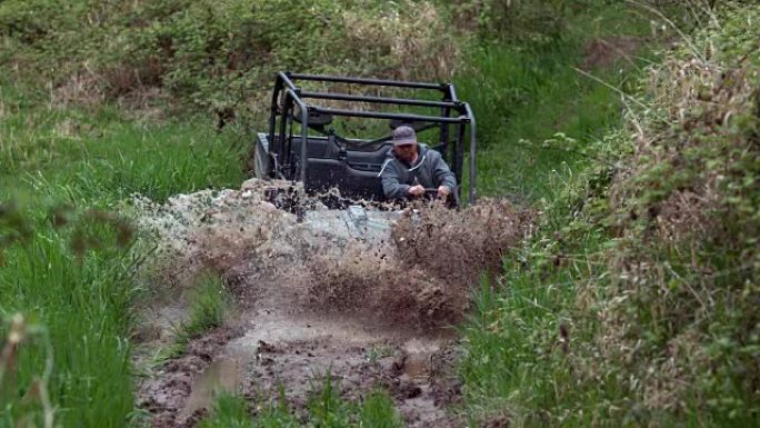男子驾驶全地形车穿过泥泞，慢动作