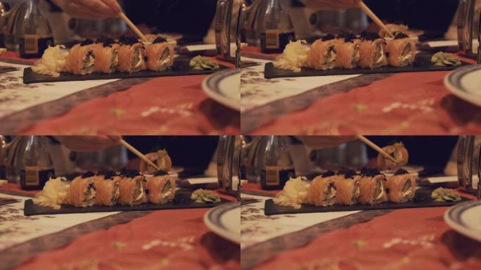 一个女孩用筷子拿寿司蘸酱油
