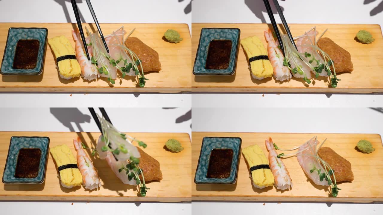 筷子从生鱼片盘中捡起生的大比目鱼，配以Kaiware豆芽，酱油和芥末。特写镜头