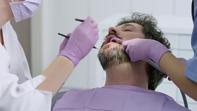 男性患者在牙医办公室修理牙齿