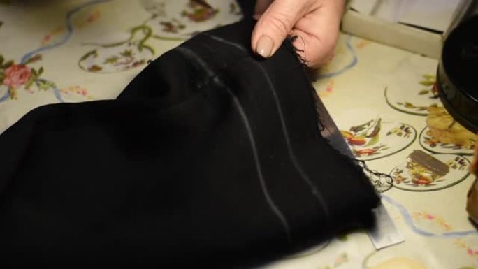 女裁缝用剪刀剪布料.