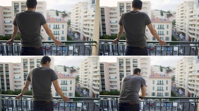 辛勤工作一天后，男性站在阳台上，在街上欣赏风景