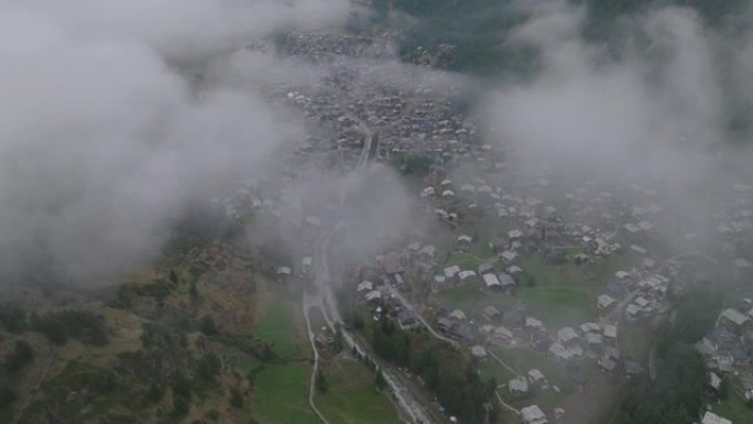 空中无人机拍摄了被低云覆盖的采尔马特小山村