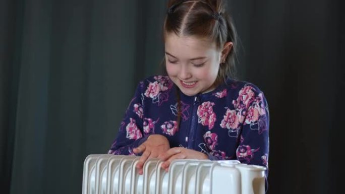 小女孩暖手靠近打开欧式房间电暖器散热器