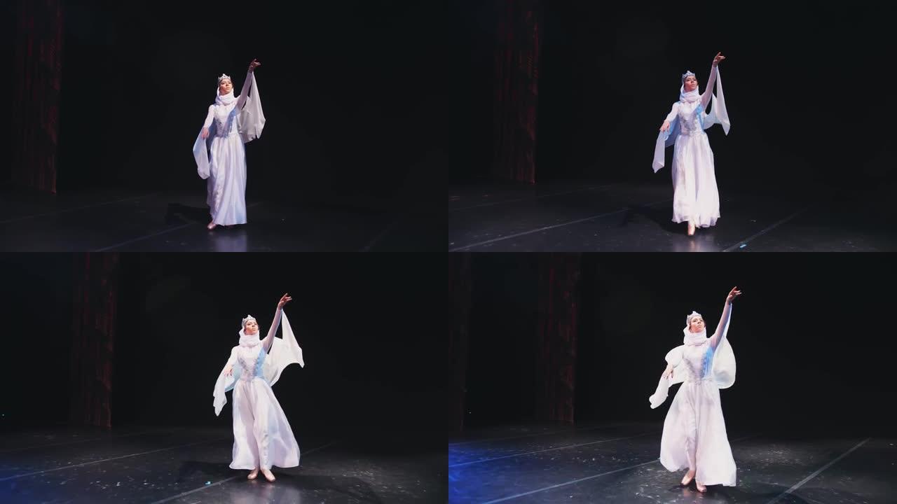 芭蕾舞演员上台。一位穿着漂亮白袍的芭蕾舞演员在黑色背景上跳舞。雷蒙达变体。