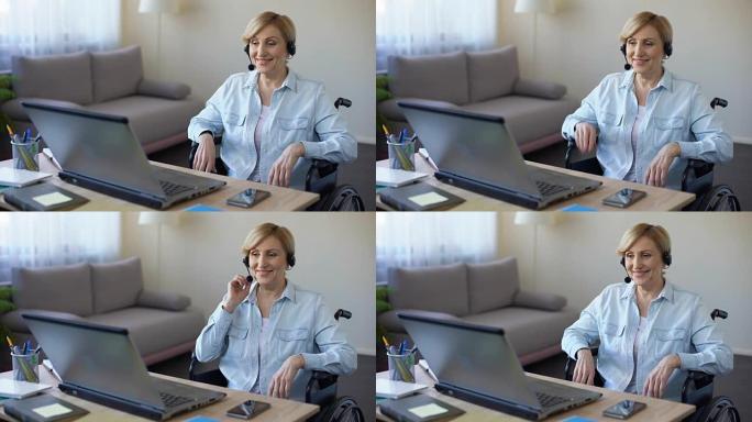 坐在轮椅上的高级女商人在笔记本电脑上工作，在线视频会议