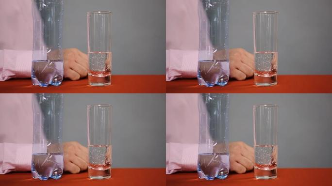 一瓶矿泉水和玻璃饮料站在桌子上