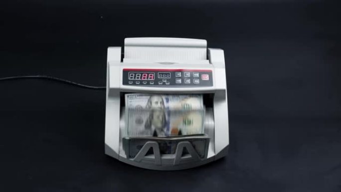 电子点钞机特写。在银行自动点钞设备上点钞。100美元纸币。点钞机，投资资本运作