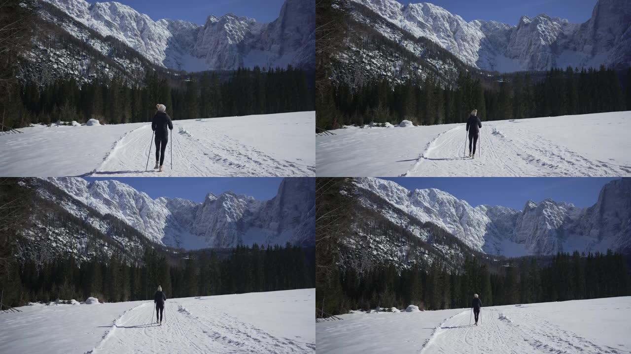 女人在雪地里徒步旅行，远离山线附近的观众