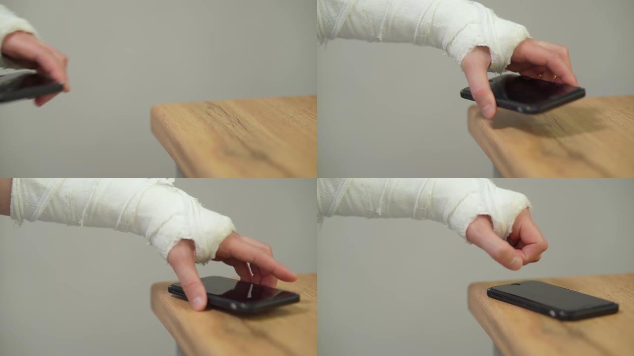 一个在石膏模型中摔断了手的人拿着智能手机。手臂上有石膏的人。