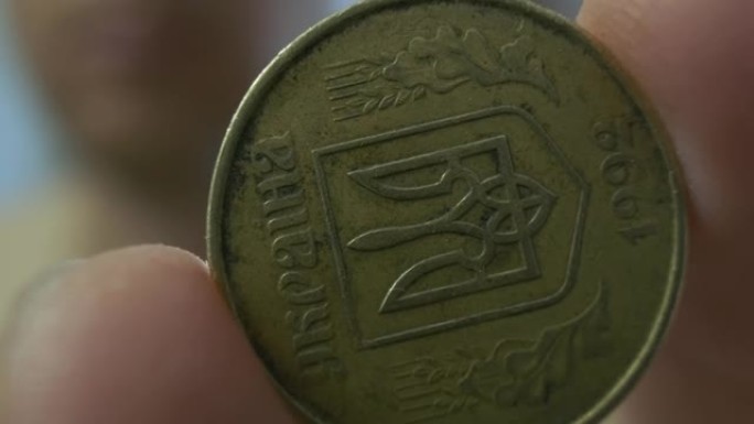 手显示硬币，极其特写，50戈比，乌克兰的货币，描绘了三叉戟。