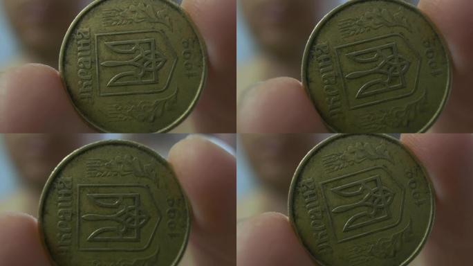 手显示硬币，极其特写，50戈比，乌克兰的货币，描绘了三叉戟。