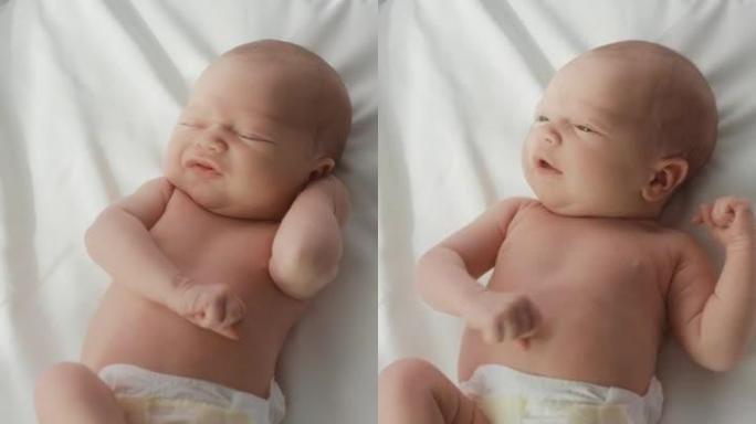 垂直屏幕: 可爱的高加索新生儿躺在托儿所的病床上。顽皮健康的小宝宝。医疗保健、生育和生育概念。自上而